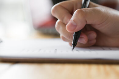 hand writing paper with pen